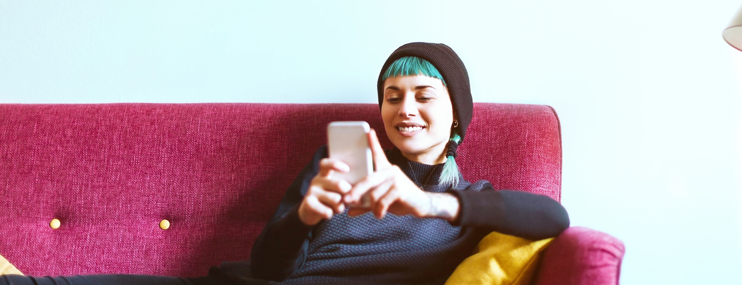 Young woman relaxing with smartphone on sofa