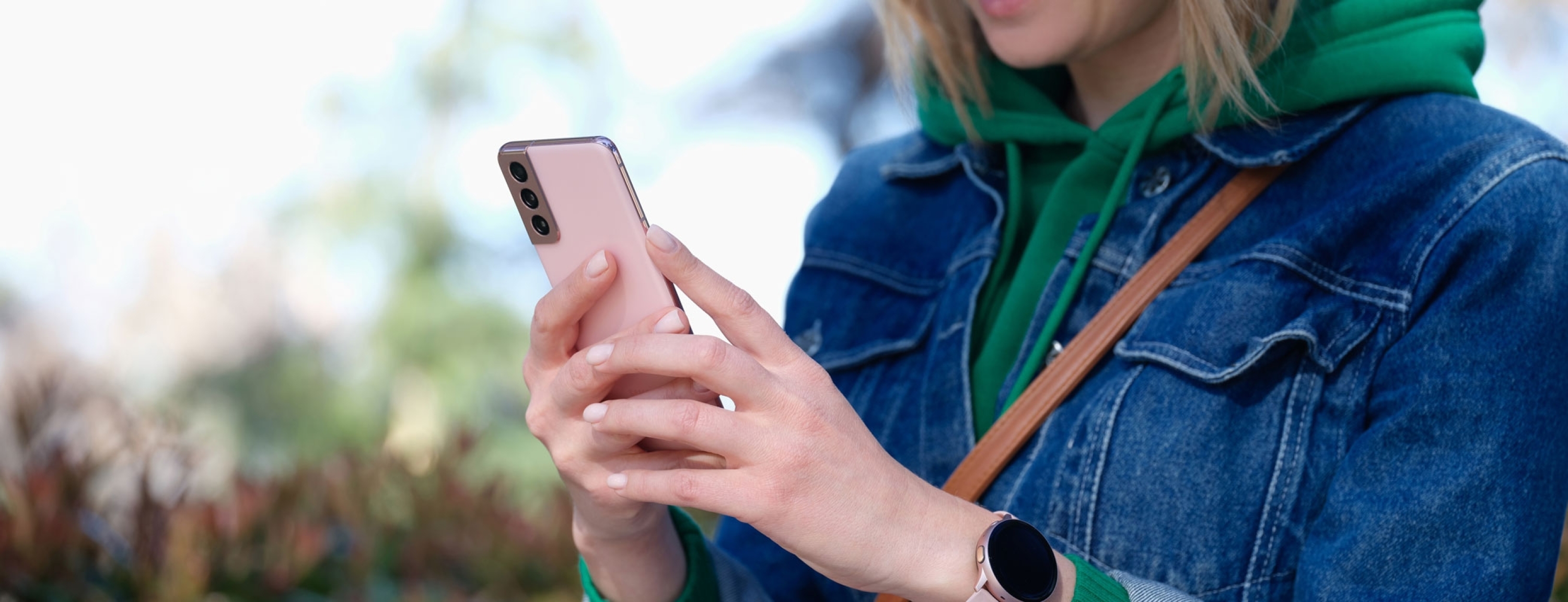 Smiling woman in sunglasses looking smartphone on street. Receive notification message and mobile apps