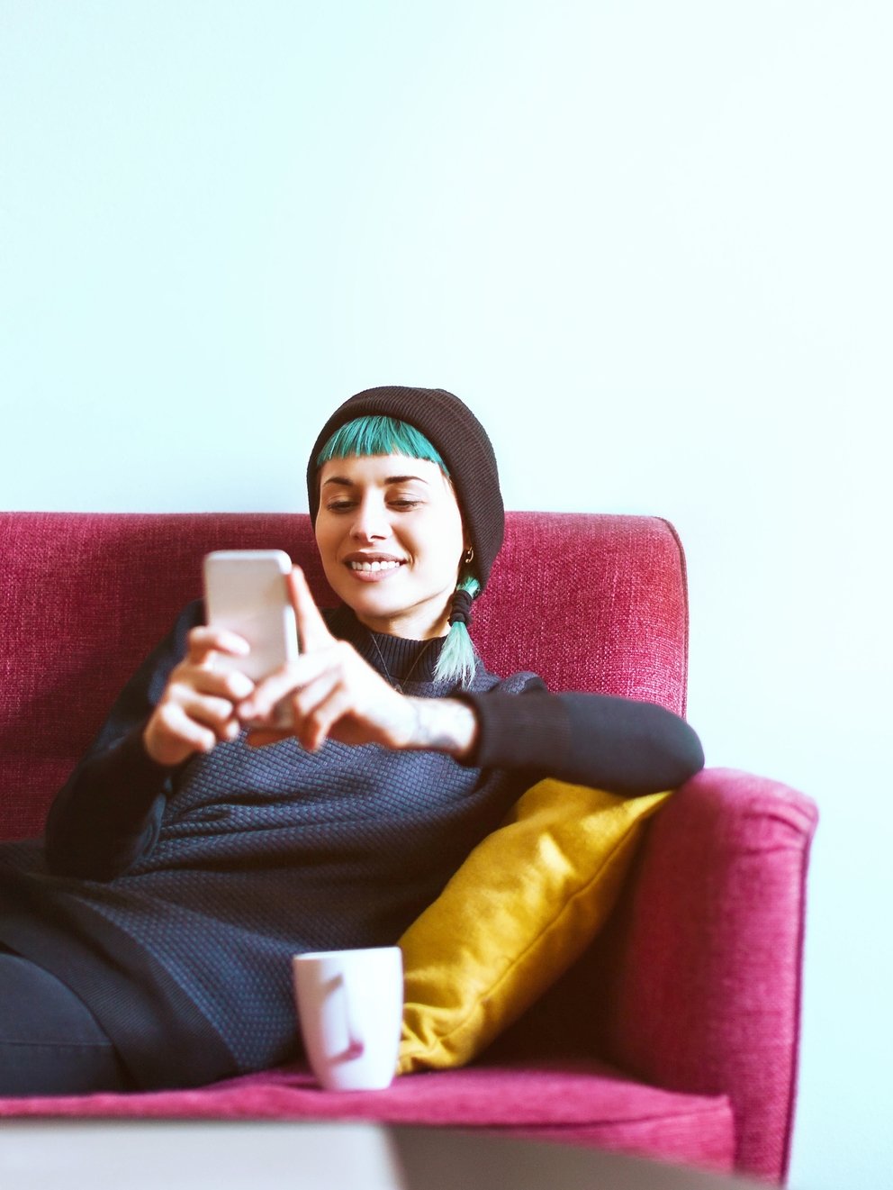 Young woman relaxing with smartphone on sofa