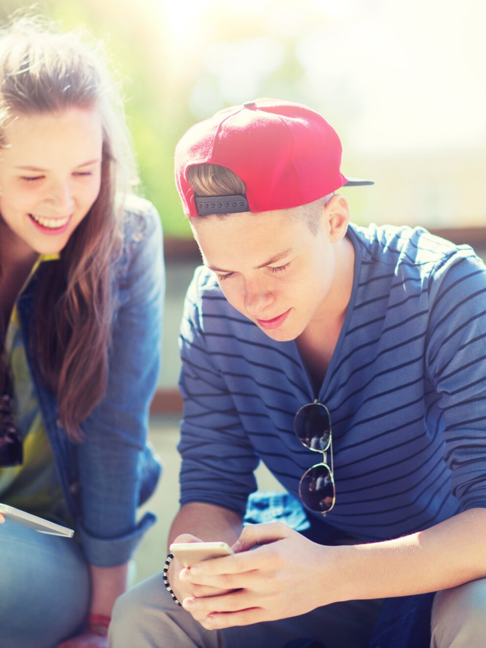 technology, internet and people concept - happy teenage friends with smartphones outdoors
